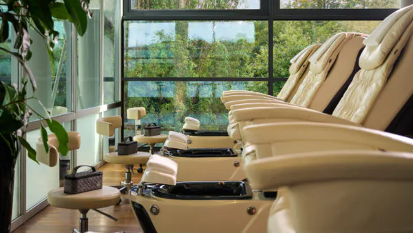 Luxurious spa lounge with plush massage chairs and serene garden view through large windows, promising ultimate relaxation.