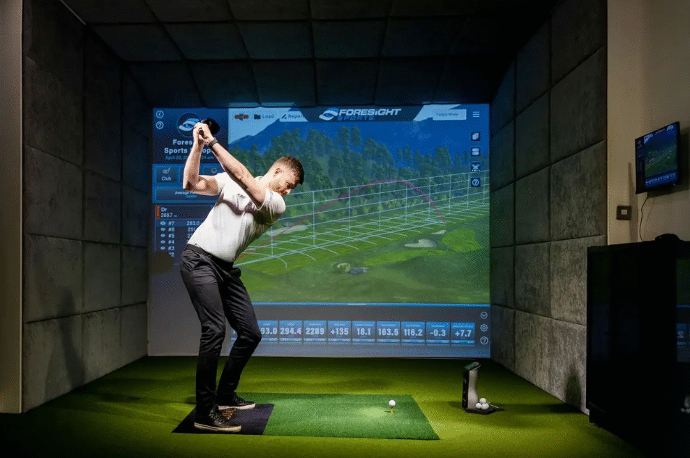 Guest enjoying state-of-the-art indoor golf simulator at luxury hotel, perfect for golf enthusiasts.