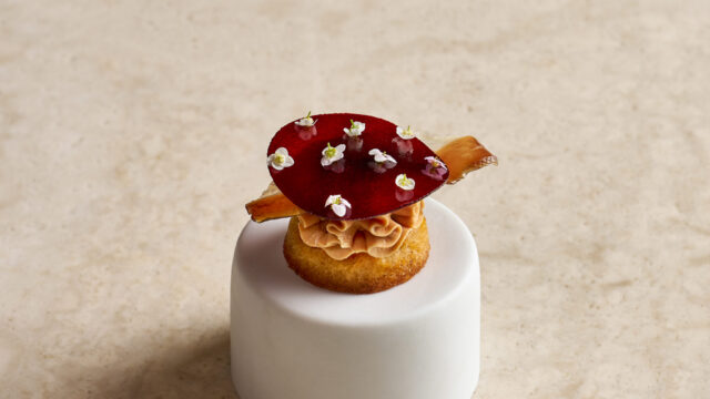 Elegant canap&eacute; with gourmet garnishes on marble, showcasing luxury hotel dining experience.