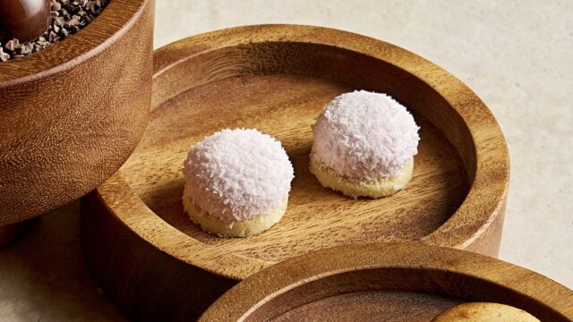 Indulge in exquisite pink coconut treats in elegant wooden bowls at our luxurious hotel, offering a taste of refined relaxation.
