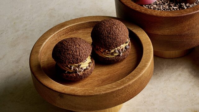 Delicious chocolate cream puffs on elegant wooden trays, showcasing our gourmet dessert experience at the hotel.