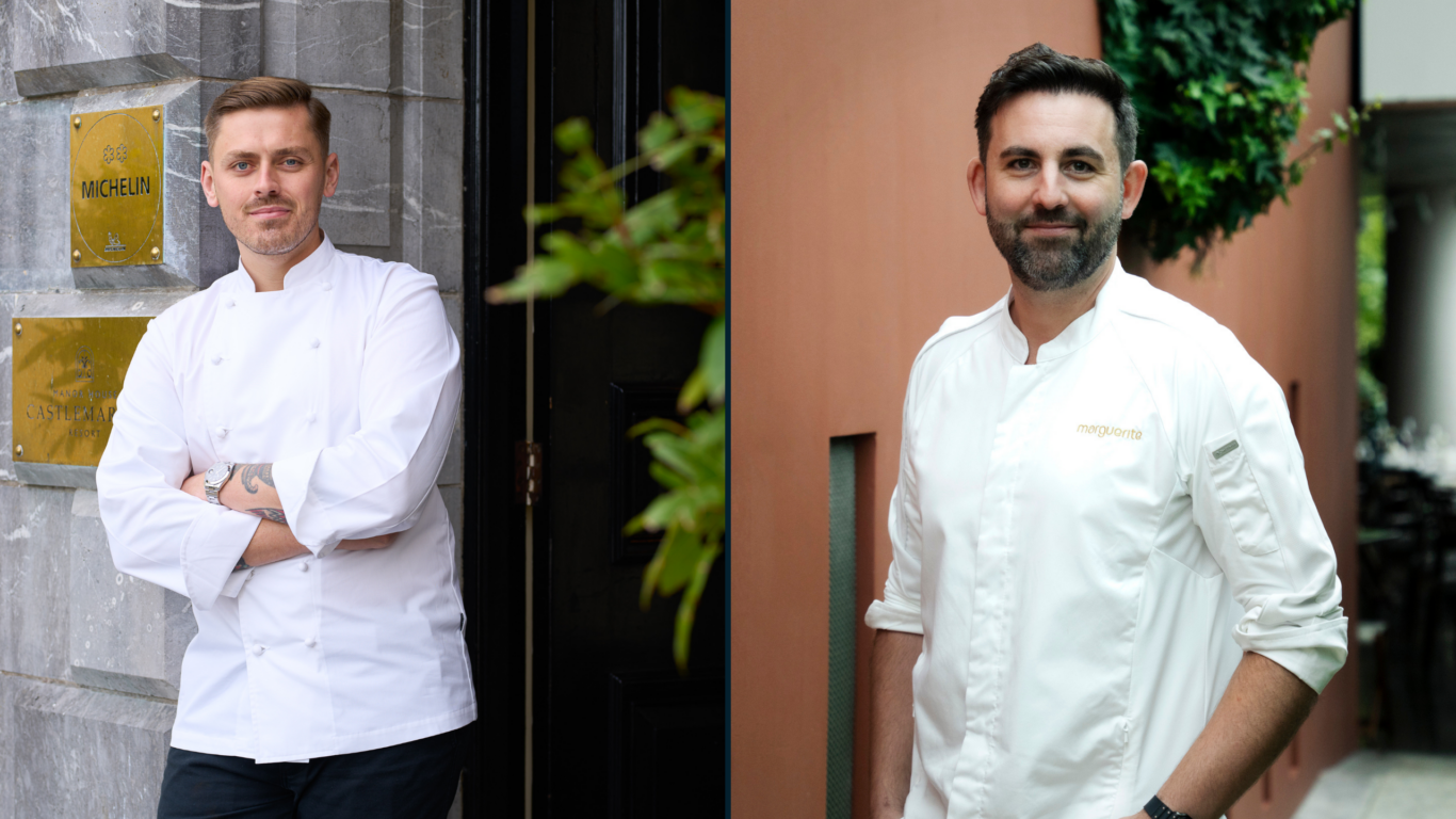Two chefs in crisp, white jackets stand outside, reflecting the hotel's gourmet dining experience and Michelin recognition.
