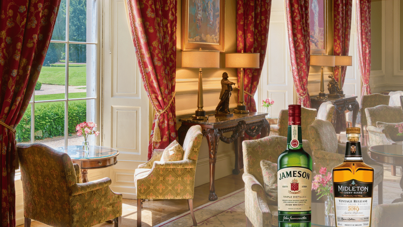 Elegant hotel lounge with plush chairs, scenic garden view, refined decor, and premium Irish whiskey bottles on display.