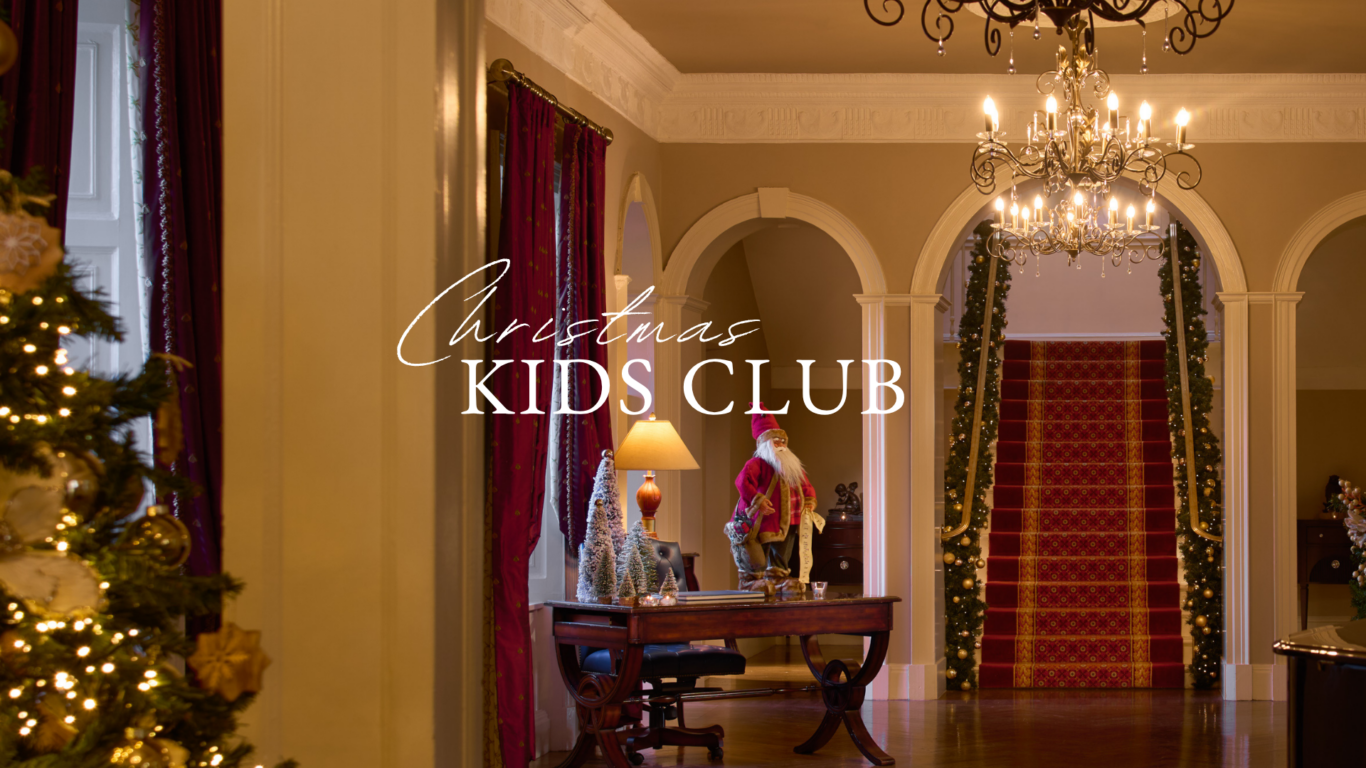 Elegant hotel lobby adorned for Christmas with festive decor, grand chandeliers, and a welcoming children's club.